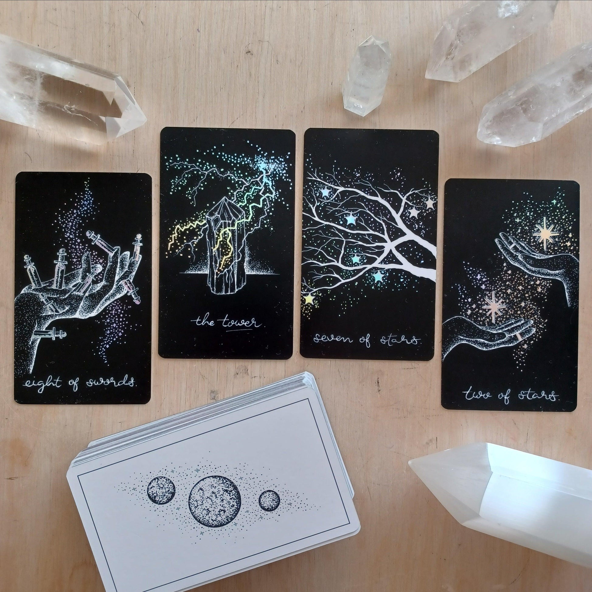 tarot spread layout, four cards across on wooden surface. features the tower tarot card