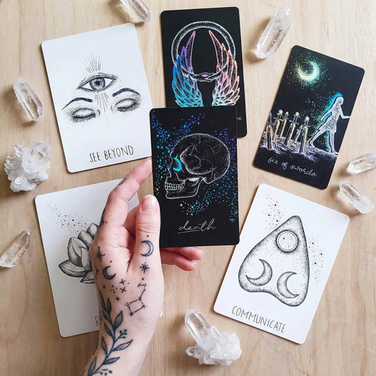 Tarot and oracle cards on a pale wooden background 
