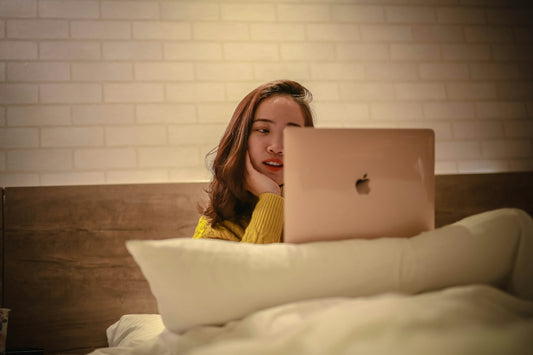 woman in yellow shirt using silver macbook