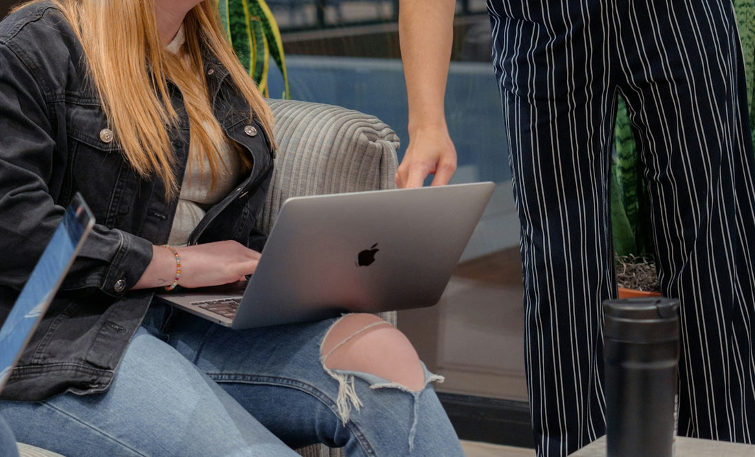 a woman sitting on a couch using a laptop computer