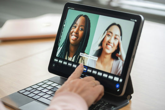 Hand touching a tablet screen showing two women smiling