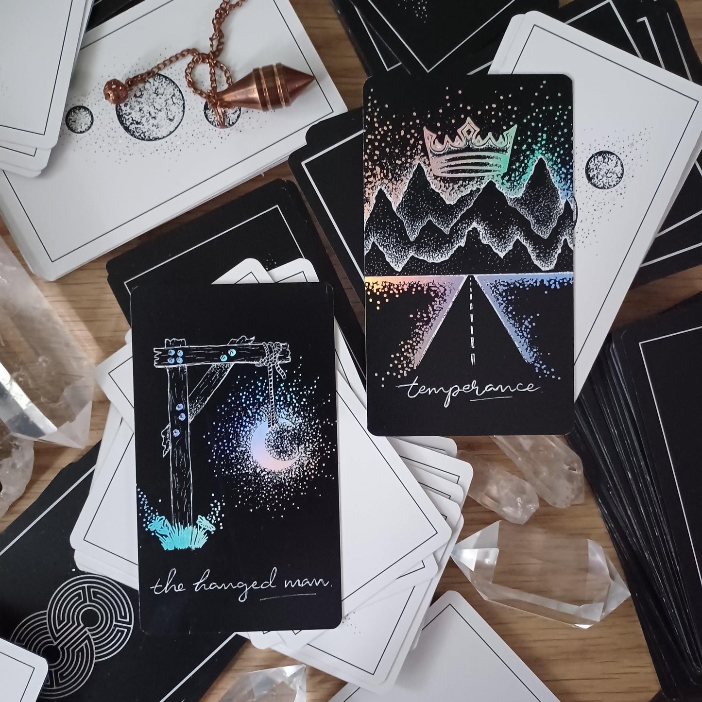 two cards rest diagonally on other decks from The Wandering Moon Co. studios