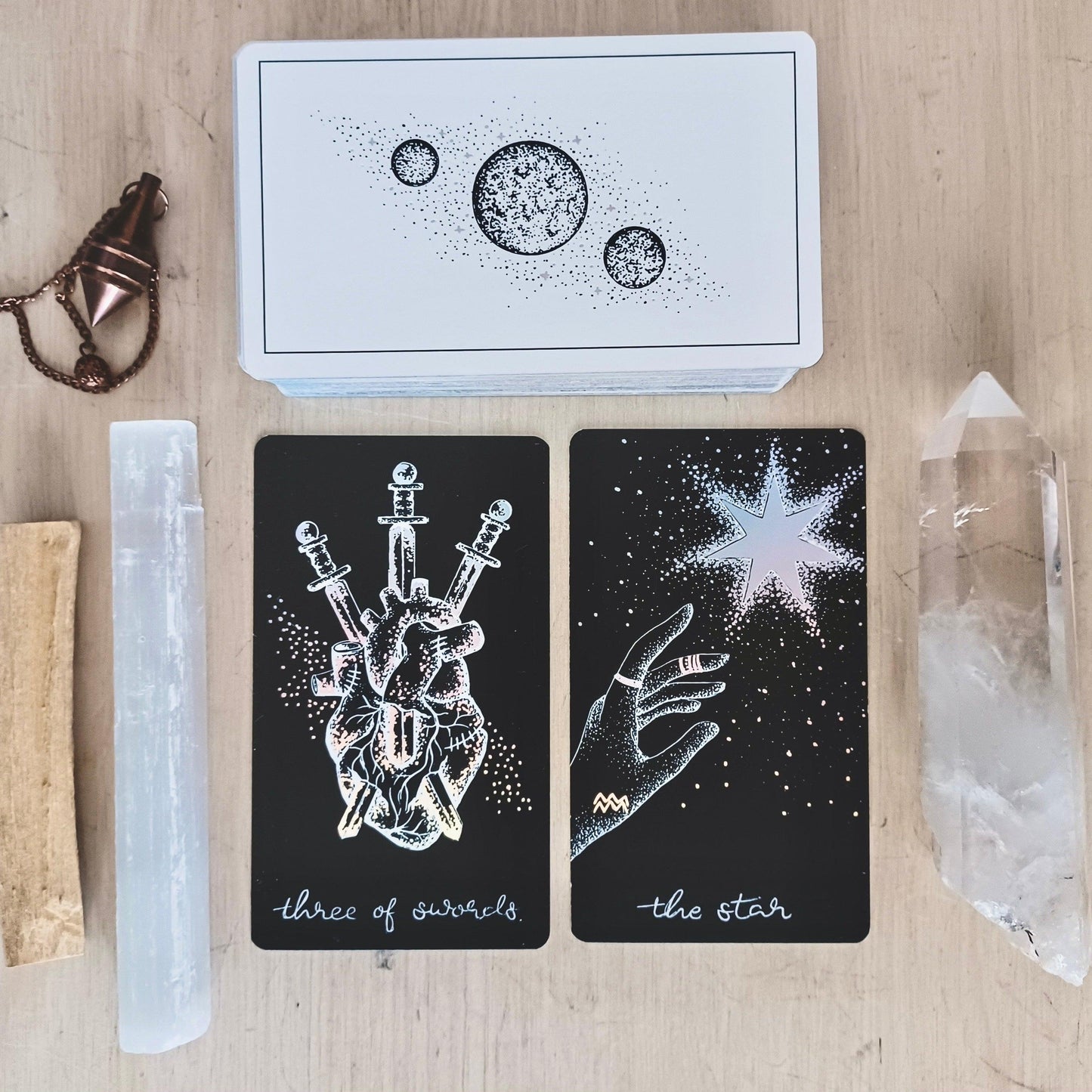 palo santo, selenite, quartz wand, pendulum, with cards from Midnight Sky indie tarot deck 